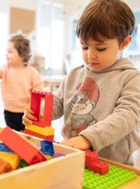 Un bambino costruisce una torre di mattoncini colorati